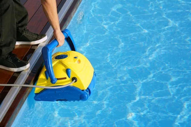 Pool cleaning robot working along the bottom of a swimming pool.