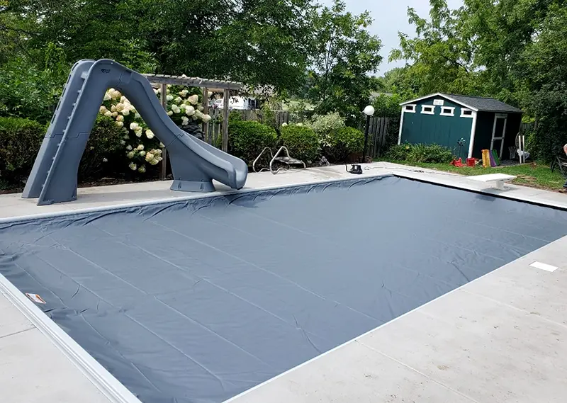 A rectangular inground swimming pool in Hugo, MN covered with an automatic safety cover.